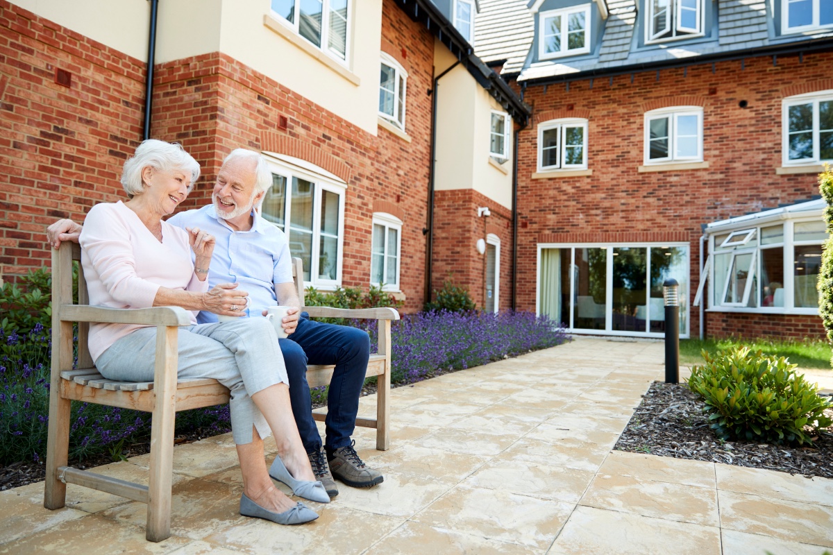 Older adults sitting outside an assisted living facility